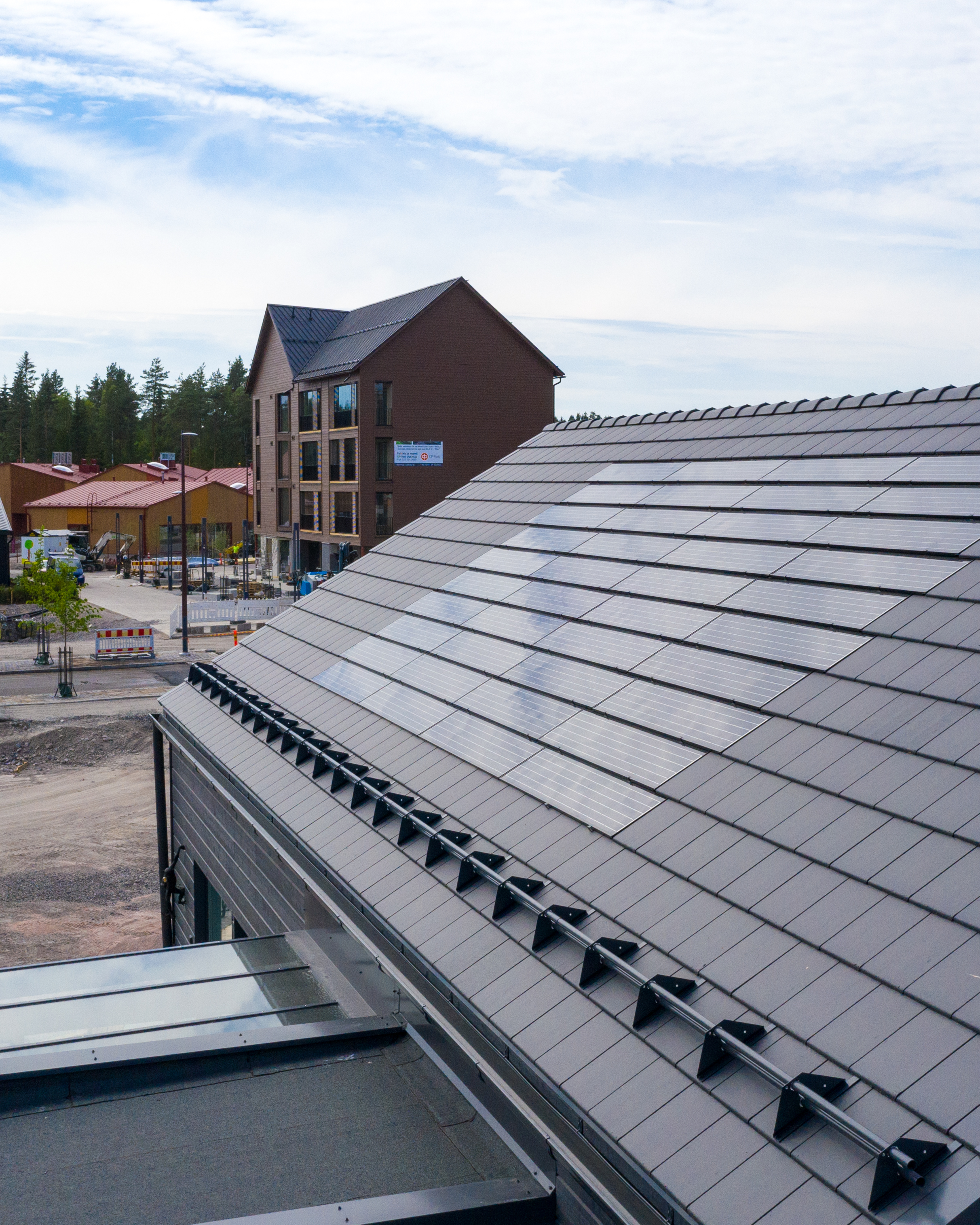 Omakotitalon katolla tiilikatteeseen integroidut aurinkopaneelit.
