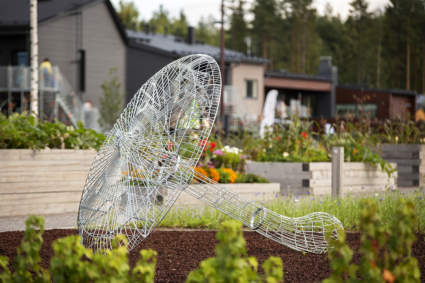 Teräslangasta taivutettu sienimäinen taideteos, joka on sijoitettu puistoon.